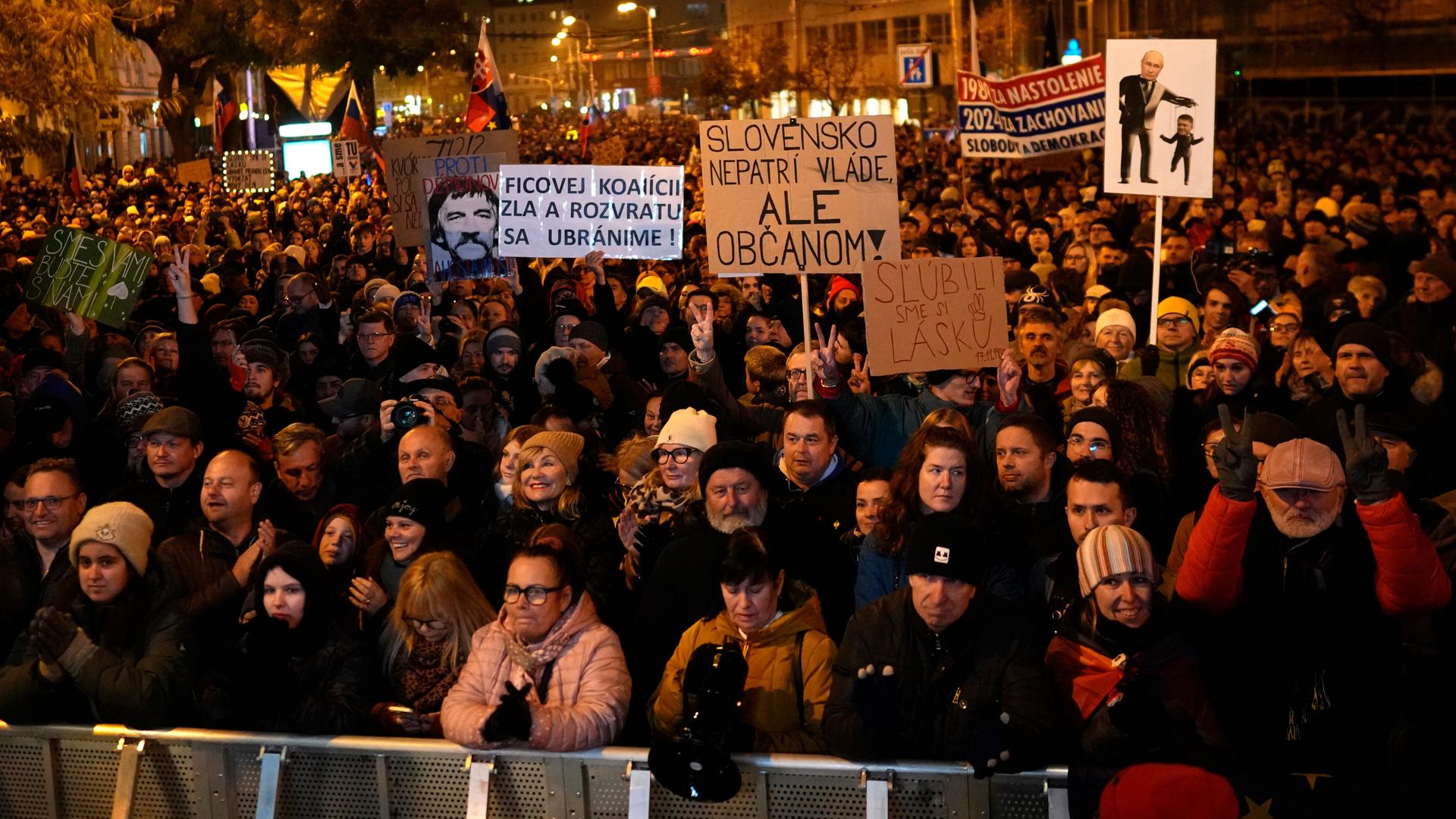 Menschen stehen bei einer Demonstration in der slowakischen Hauptstadt Bratisalava eng gedrängt auf der Straße; einige halten Schilder hoch. 