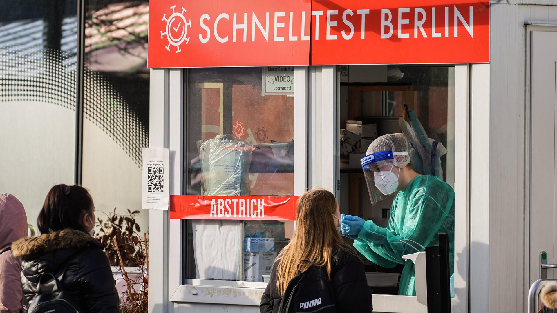 An einer Teststation in Berlin wird ein Abstrich bei einer Frau gemacht.