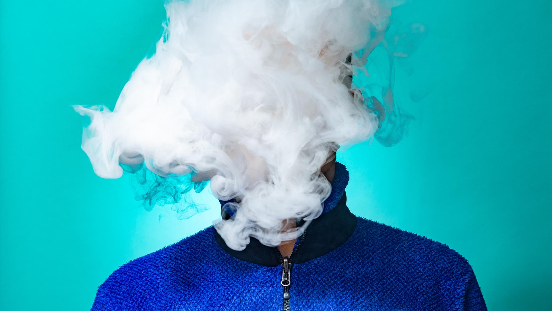 Eine Person hinter einer Wolke von Rauch
