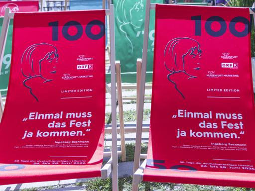 Zwei rote Strandliegen mit dem Konterfei der Dichterin Ingeborg Bachmann und der Ziffer 100 auf dem Stoff stehen im Garten des ORF Landesstudios.