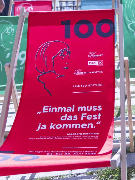 Zwei rote Strandliegen mit dem Konterfei der Dichterin Ingeborg Bachmann und der Ziffer 100 auf dem Stoff stehen im Garten des ORF Landesstudios.
