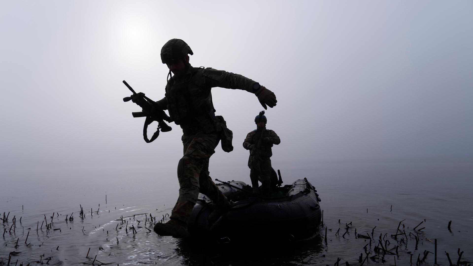 Das Bild zeigt einen ukrainische Soldaten, der am Ufer des Dnipro-Flusses an der Frontlinie nahe Cherson aus einem Boot steigt. Die Aufnahme stammt von Oktober 2023.