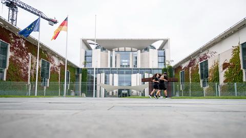 Zwei Jogger laufenam Bundeskanzleramt in Berlin-Mitte vorbei.