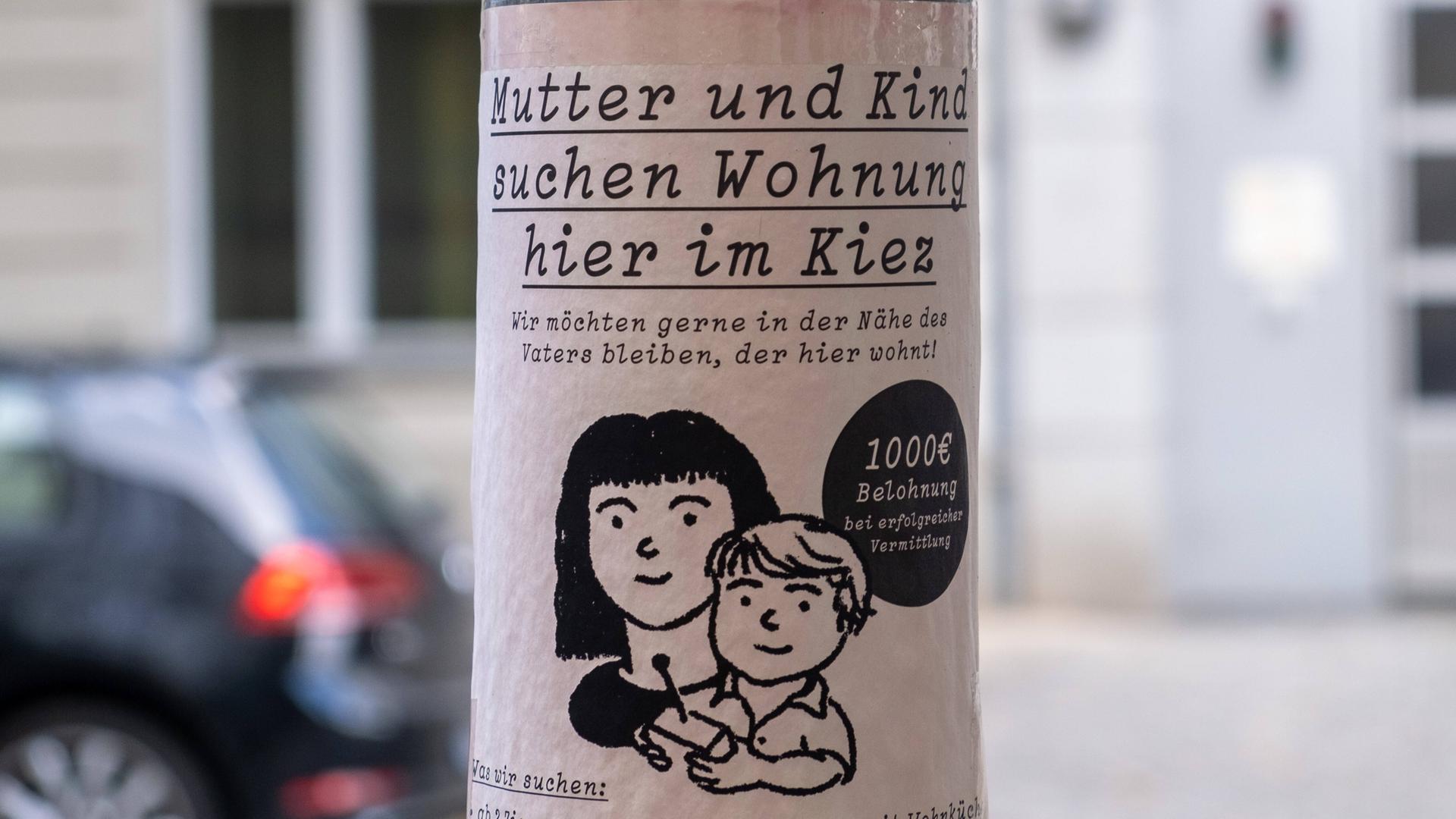 Wochnungsgesuch an einem Laternenpfahl, auf dem steht: "Mutter und Kind suchen Wohnung hier im Kiez".