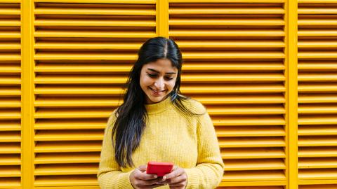 Eine junge Frau an einem Smartphone