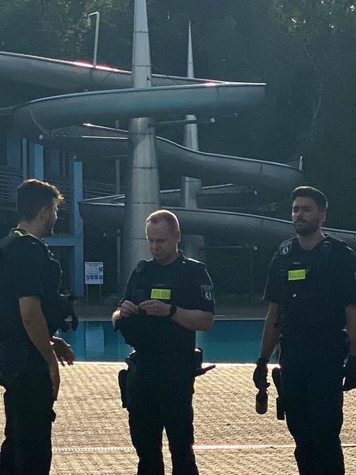 Polizisten stehen nach der Räumung im Sommerbad Neukölln am Berliner Columbiadamm.