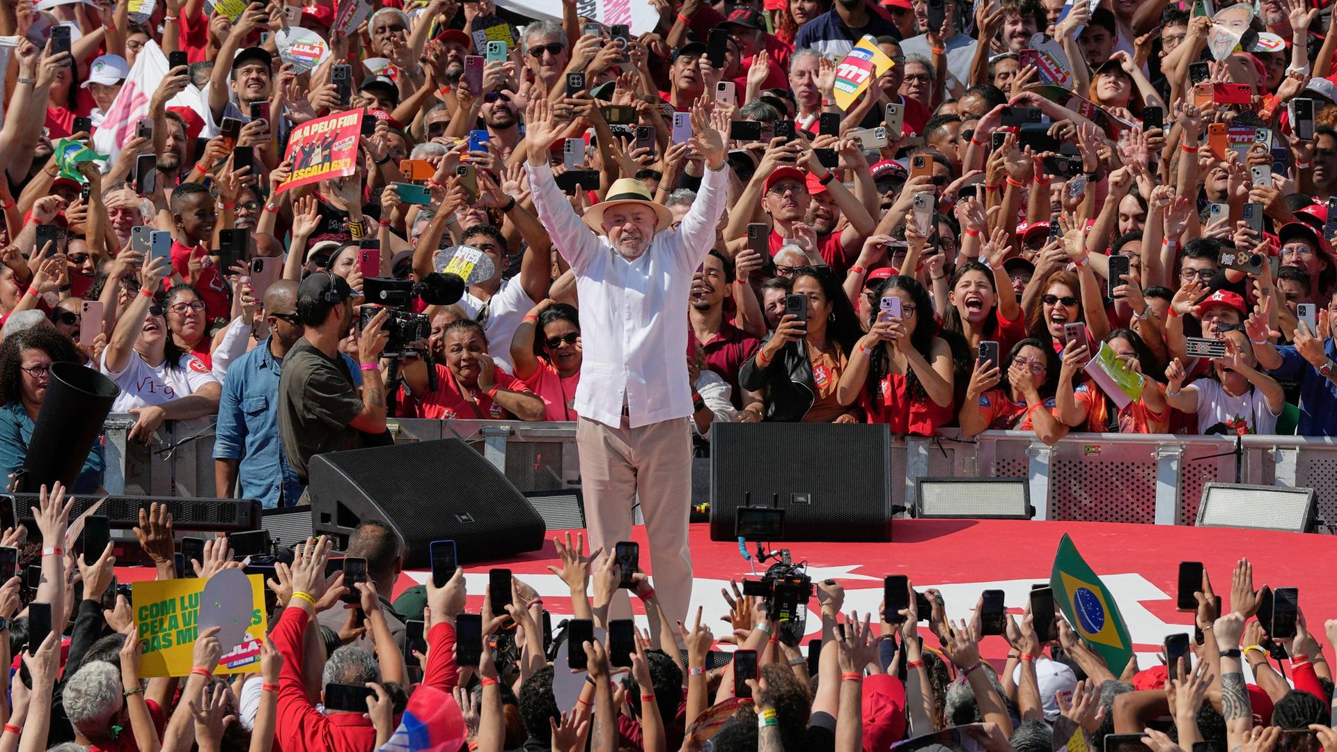 Luiz Inacio Lula da Silva winkt seinen Anhängern während einer Wahlkampfveranstaltung zu, vor und hinter ihm sind zahlreiche jubelnde Menschen zu sehen. Luiz Inacio Lula da Silva winkt seinen Anhängern während einer Wahlkampfveranstaltung zu, vor und hinter ihm sind zahlreiche jubelnde Menschen zu sehen.