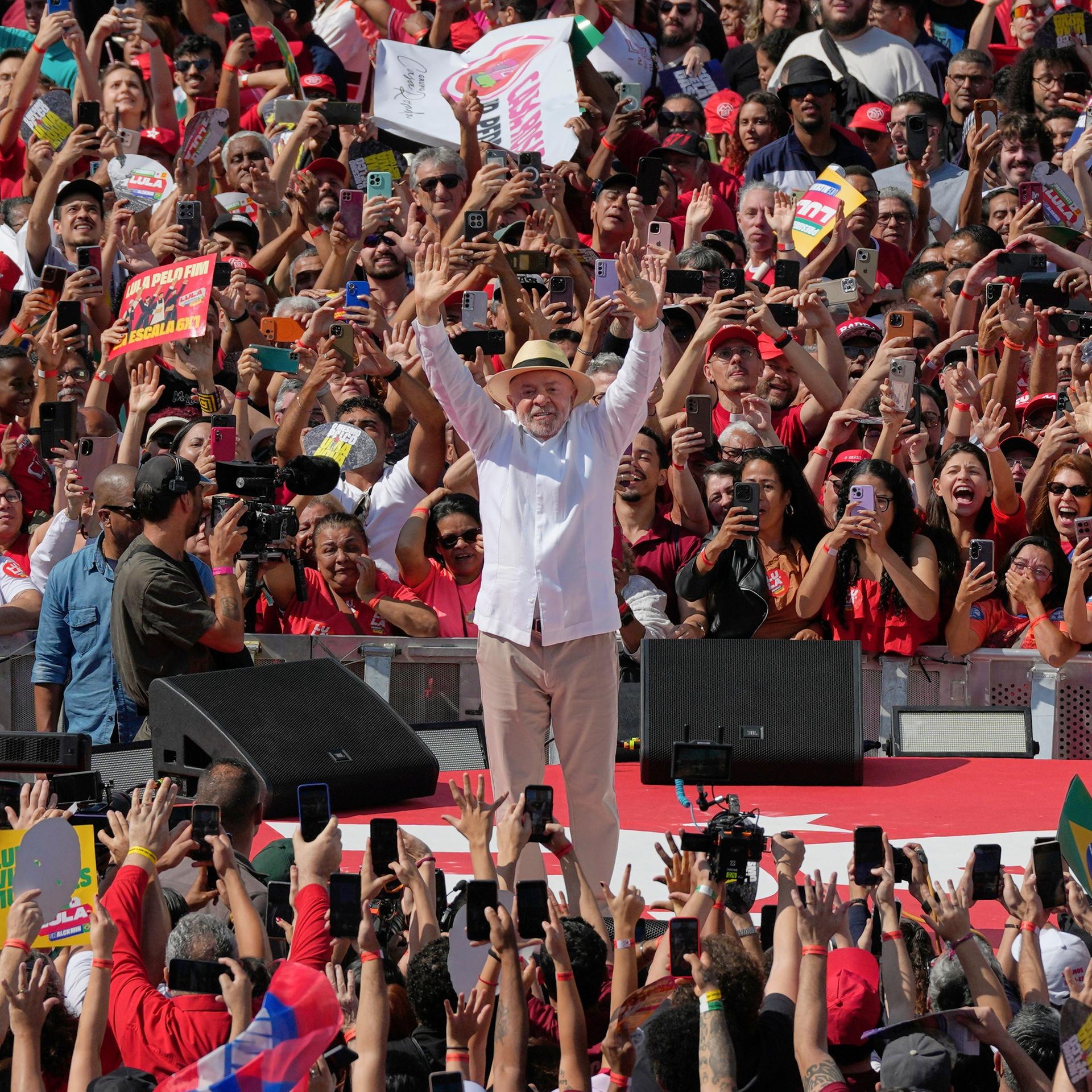 Luiz Inacio Lula da Silva winkt seinen Anhängern während einer Wahlkampfveranstaltung zu, vor und hinter ihm sind zahlreiche jubelnde Menschen zu sehen.