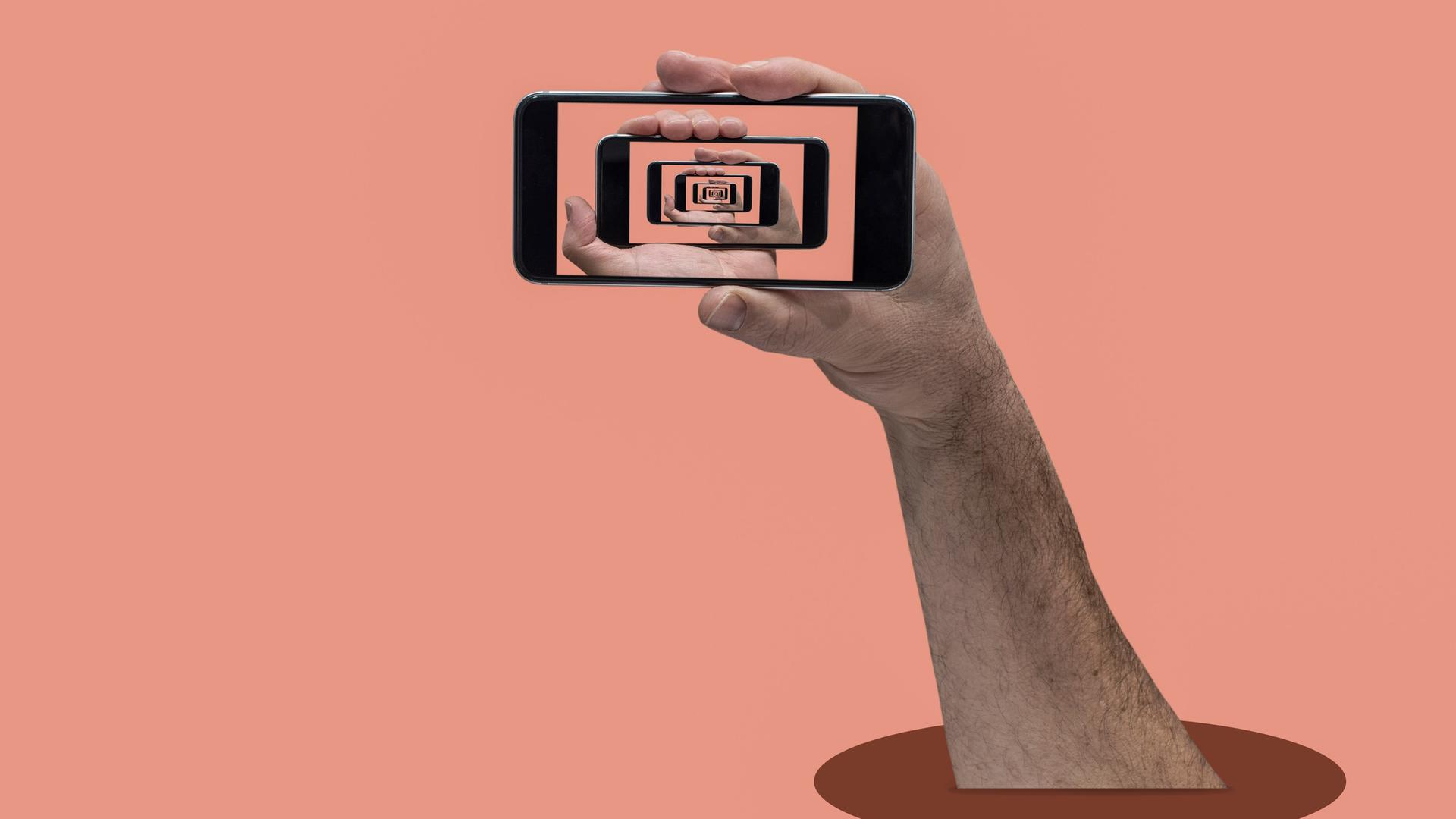 Eine Hand vor pfirsichfarbenem Hintergrund hält ein Smartphone auf dessen Bildschirm immer wieder die Hand und das Sartphone zu sehen sind.