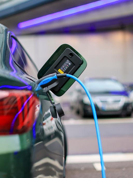 Ein Elektroauto lädt an einer Ladesäule. Ein Elektroauto lädt an einer Ladesäule.