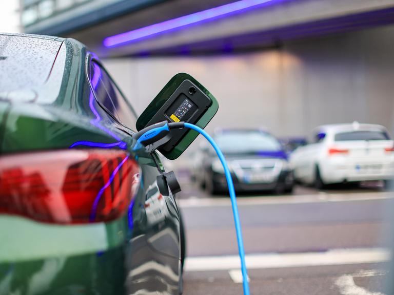 Ein Elektroauto lädt an einer Ladesäule. Ein Elektroauto lädt an einer Ladesäule.