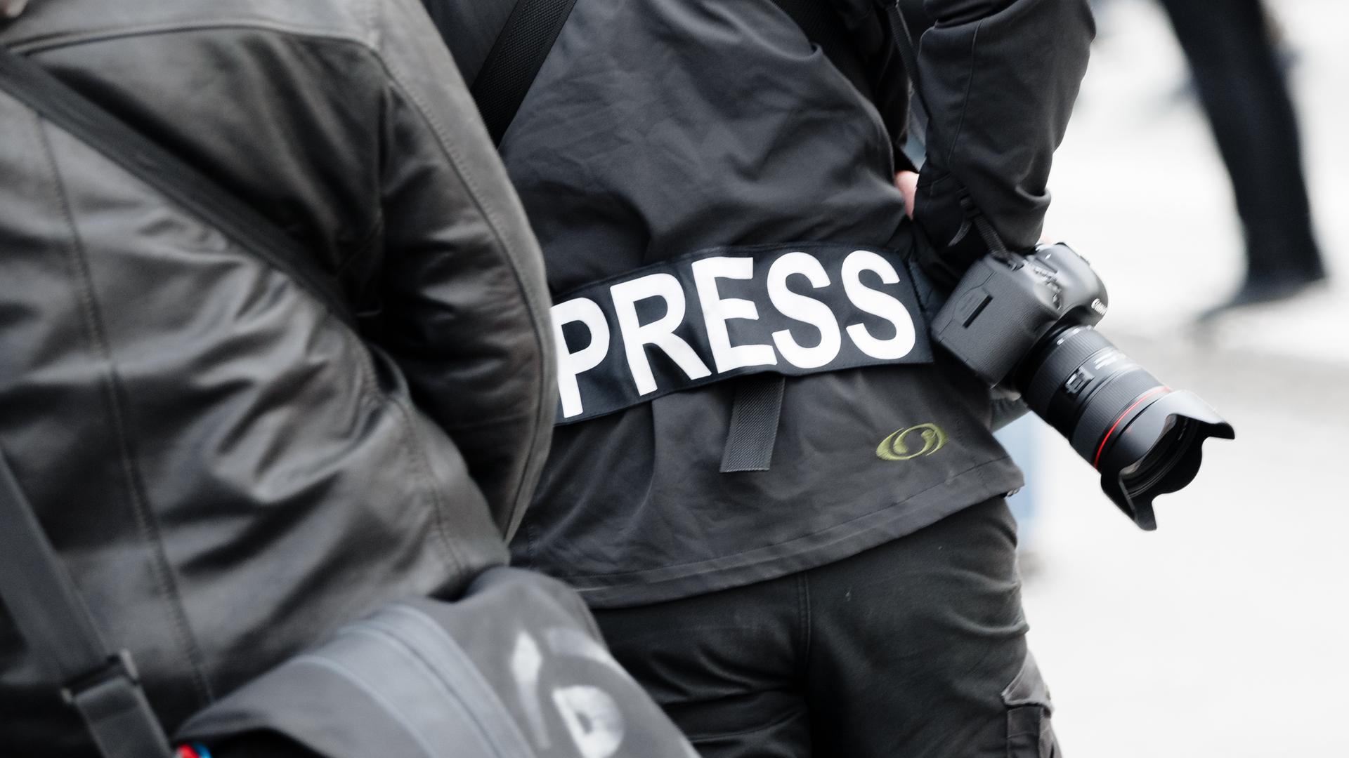 Ein Fotoreporter trägt auf einer Demonstration einen Aufnäher mit dem Text «PRESS» auf seiner Jacke.