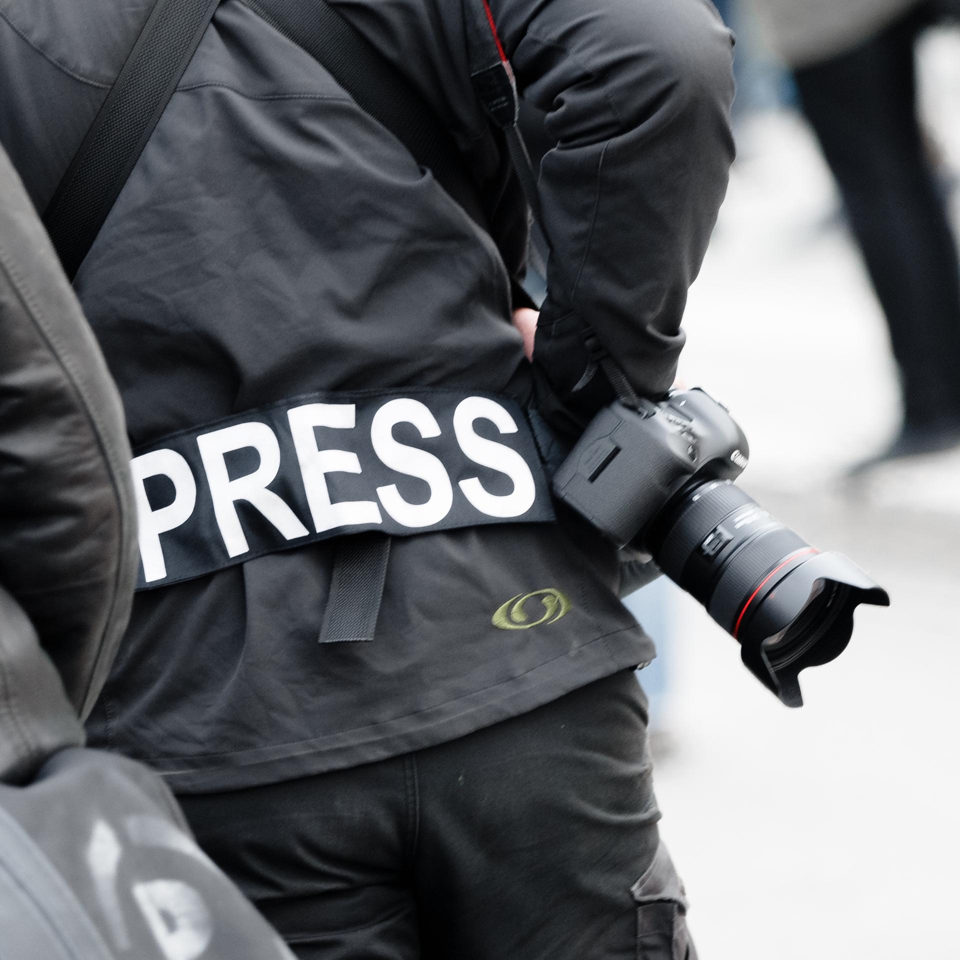 Ein Fotoreporter trägt auf einer Demonstration einen Aufnäher mit dem Text «PRESS» auf seiner Jacke.