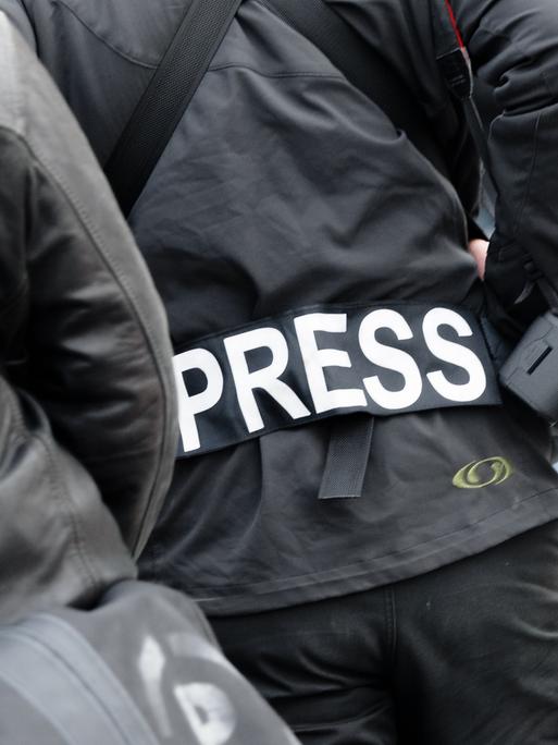 Ein Fotoreporter trägt auf einer Demonstration einen Aufnäher mit dem Text «PRESS» auf seiner Jacke.