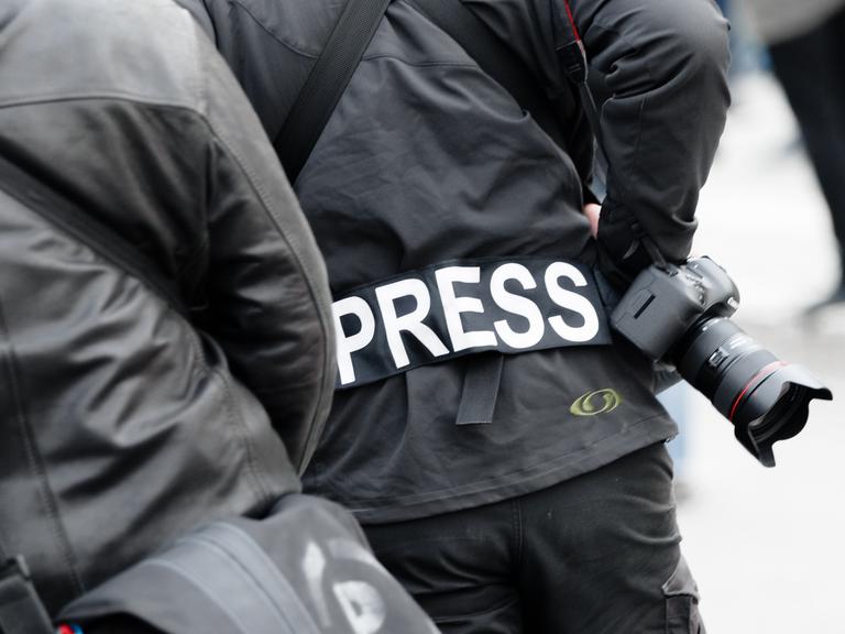 Ein Fotoreporter trägt auf einer Demonstration einen Aufnäher mit dem Text «PRESS» auf seiner Jacke.