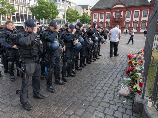 Minuten nach dem Bekanntwerden seines Todes trauern Polizisten auf dem Marktplatz in Mannheim um ihren getöteten Kollegen. Der Polizist war hier von einem Mann mit einem Messer niedergestochen und lebensgefährlich verletzt worden.