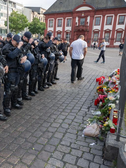 Minuten nach dem Bekanntwerden seines Todes trauern Polizisten auf dem Marktplatz in Mannheim um ihren getöteten Kollegen. Der Polizist war hier von einem Mann mit einem Messer niedergestochen und lebensgefährlich verletzt worden.
