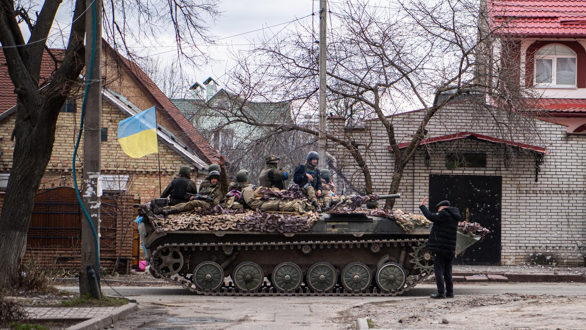 Ein ukrainischer Panzer fährt mit Soldaten auf einer Straße in Irpin, einer Stadt in der Nähe von Kiew