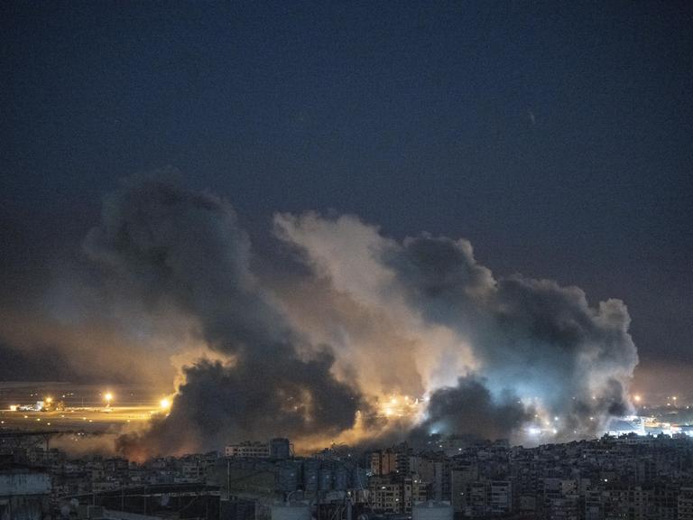 Nachts sind Rauch und Flammen sind über einem Vorort von Beirut zu sehen.