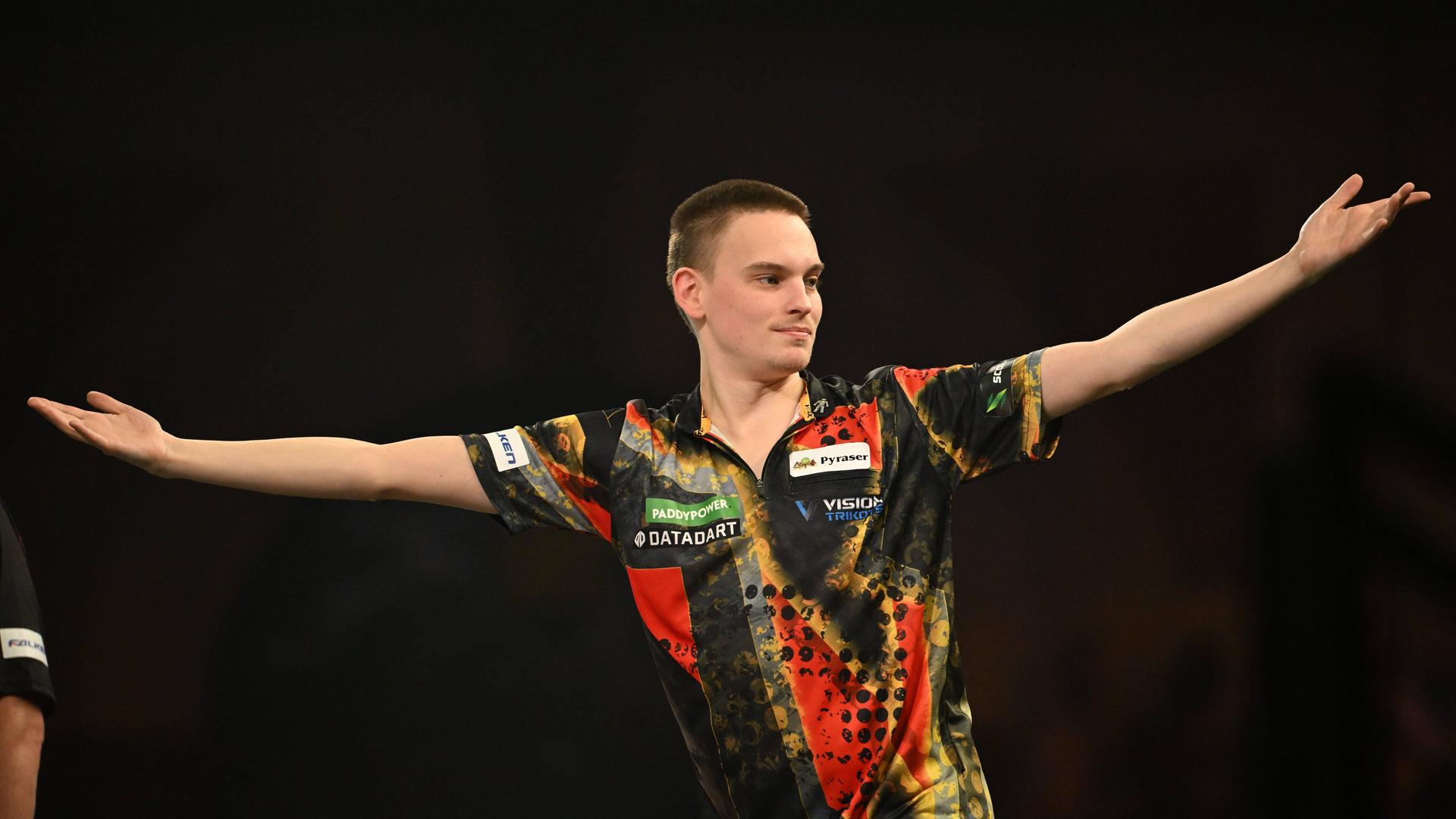 Der Darts-Spieler Ricardo Pietreczko hebt beide Arme. 
