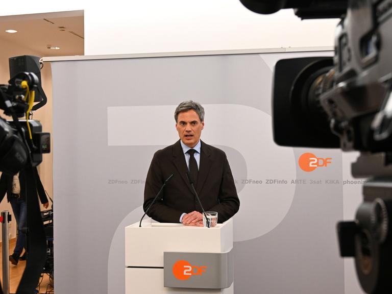 Norbert Himmler steht vor Kameras an einem Pult mit ZDF-Logo.