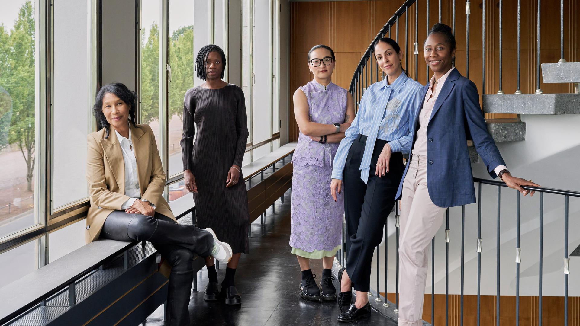 Das Künstlerische Team der documenta 16 steht in einem Treppenhaus. Alle lächeln in die Kamera.