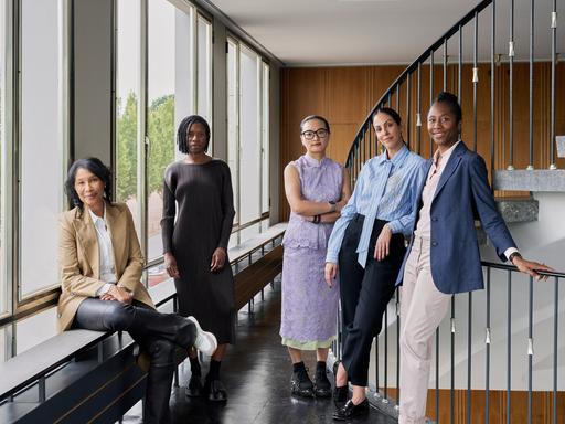 Das Künstlerische Team der documenta 16 steht in einem Treppenhaus. Alle lächeln in die Kamera.