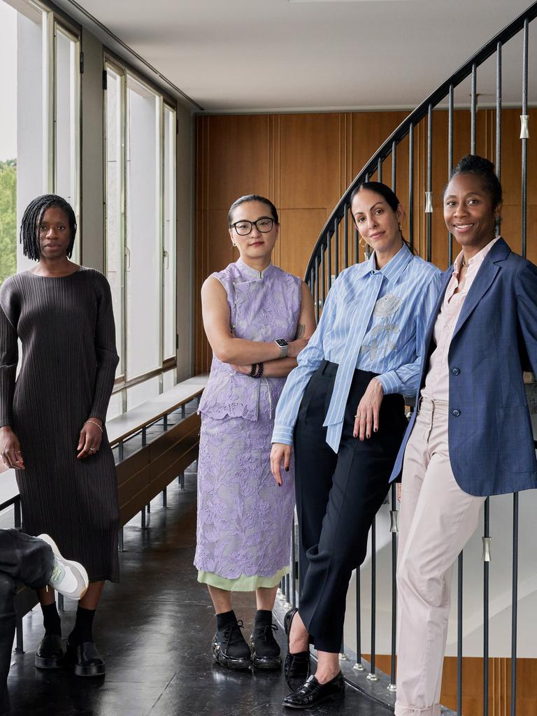 Das Künstlerische Team der documenta 16 steht in einem Treppenhaus. Alle lächeln in die Kamera.