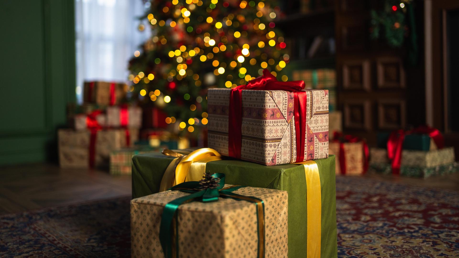 Viele Geschenke stehen vor einem Weihnachtsbaum