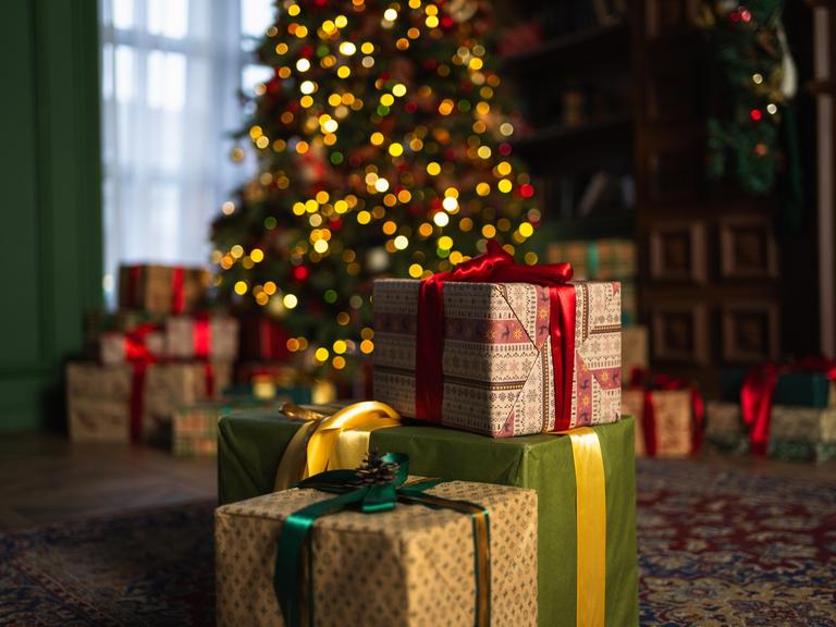 Viele Geschenke stehen vor einem Weihnachtsbaum