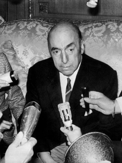 Pablo Neruda spricht am 21. Oktober 1971 in der chilenischen Botschaft in Paris in mehrere Mikrofone. Links neben ihm sitzt seine Frau Mathilde Urrutia.