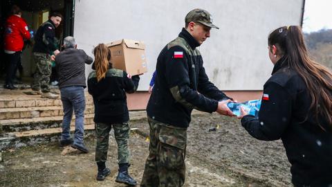 Polnische Helfer verladen Lebensmittel und Wasser für ukrainische Flüchtlinge. 
