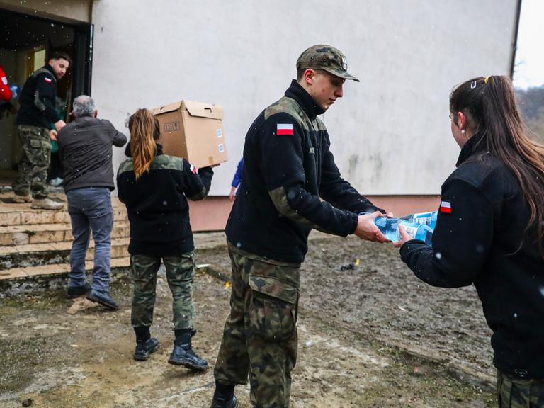 Polnische Helfer verladen Lebensmittel und Wasser für ukrainische Flüchtlinge. 