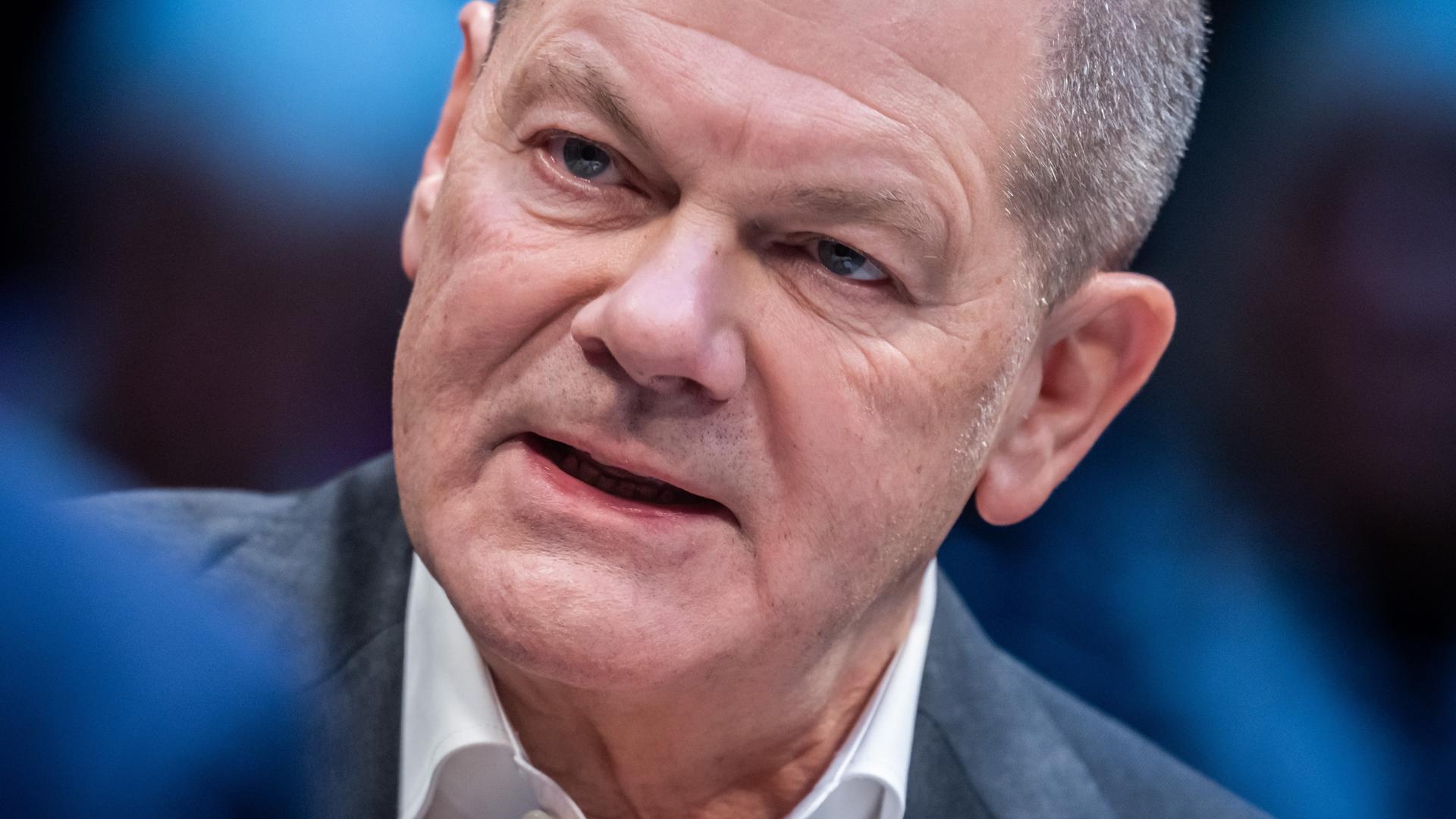 Bundeskanzler Olaf Scholz neigt seinen Kopf und spricht.