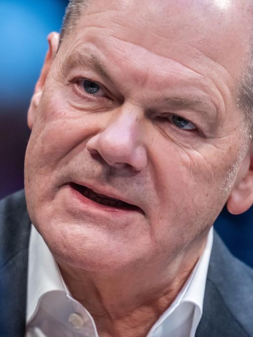 Bundeskanzler Olaf Scholz neigt seinen Kopf und spricht.