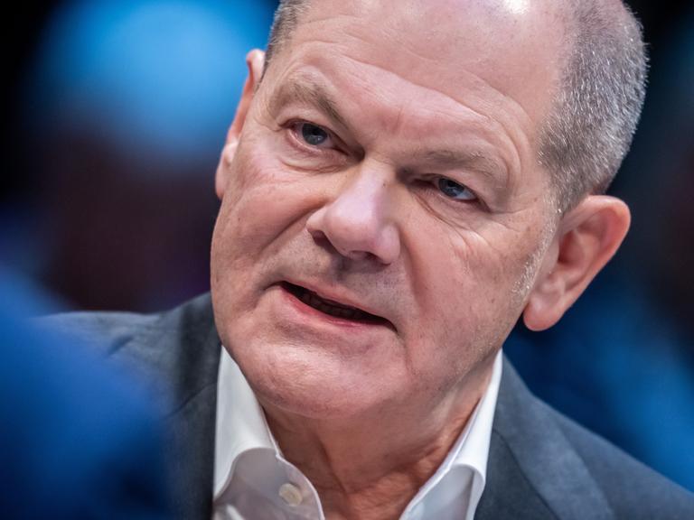 Bundeskanzler Olaf Scholz neigt seinen Kopf und spricht.