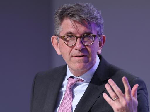 Kulturstaatsminister Wolfram Weimer gestikuliert vor einem grauen Hintergrund