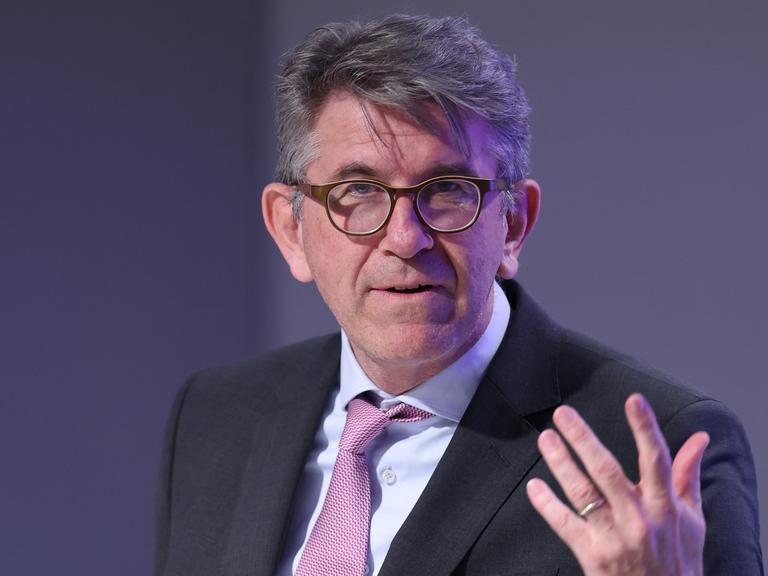 Kulturstaatsminister Wolfram Weimer gestikuliert vor einem grauen Hintergrund