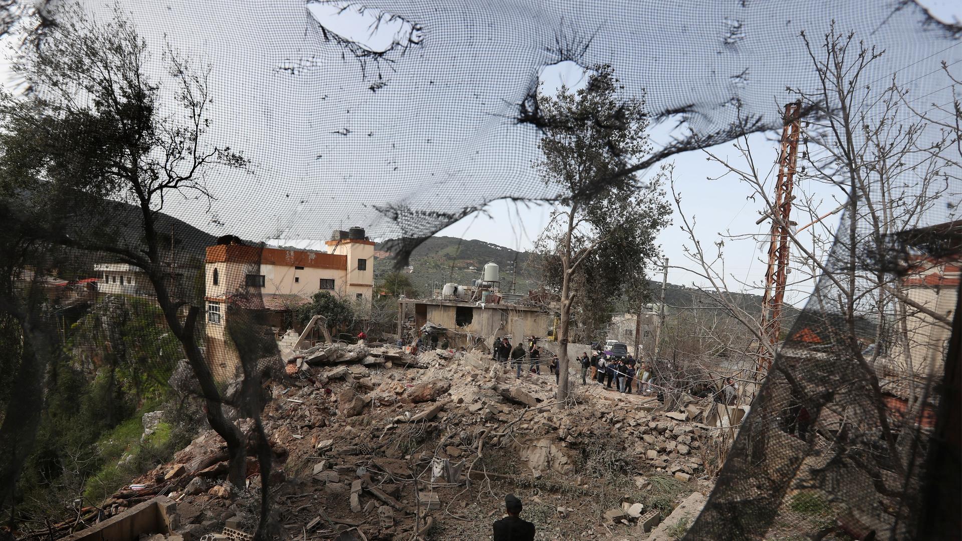 Menschen stehen neben und auf den Trümmern eines Sanitätszentrums, das durch einen israelischen Luftangriffim Dorf Hebbariye im Südlibanon zerstört wurde.