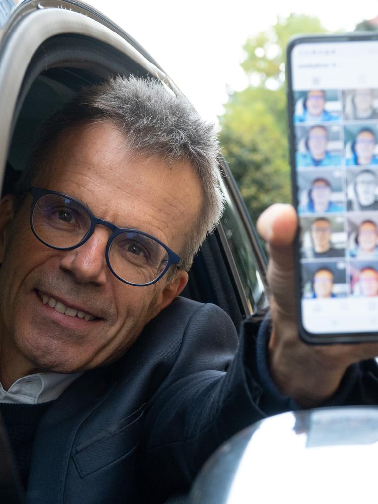 Uwe Baltner sitzt in seinem Auto und zeigt auf seinem Handy sein Instagram-Profil. 