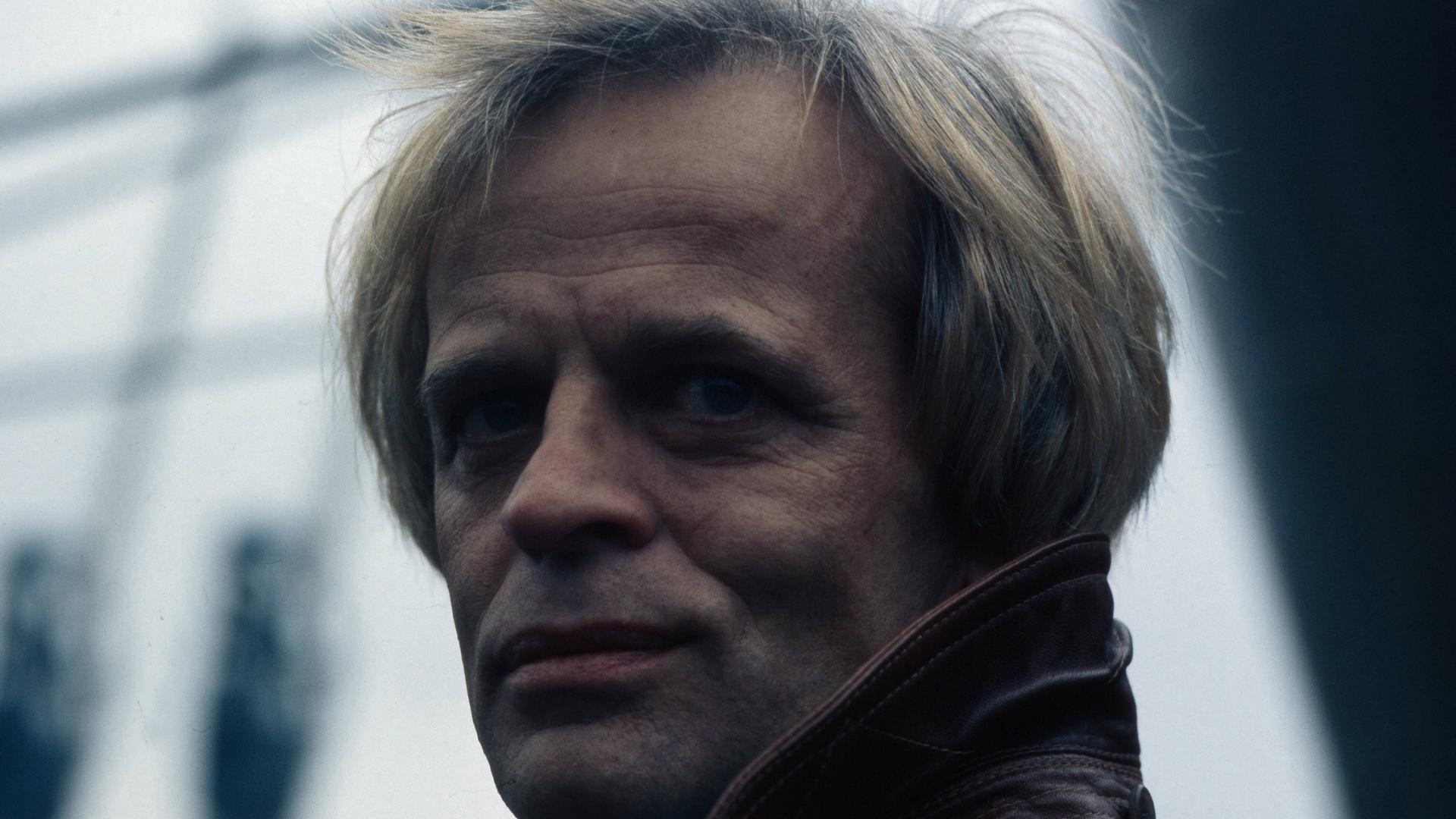 Der deutsche Schauspieler Klaus Kinski im Hafen von Hamburg. Der damalige Endvierziger trägt eine Lederjacke. Er hat blonde Haare. Der deutsche Schauspieler Klaus Kinski im Hafen von Hamburg. Der damalige Endvierziger trägt eine Lederjacke. Er hat blonde Haare.