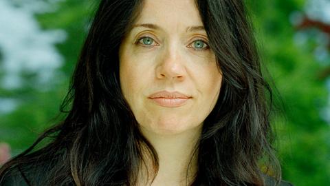 Portrait ein Frau mit dunklem Haar, die freundlich in die Kamera schaut