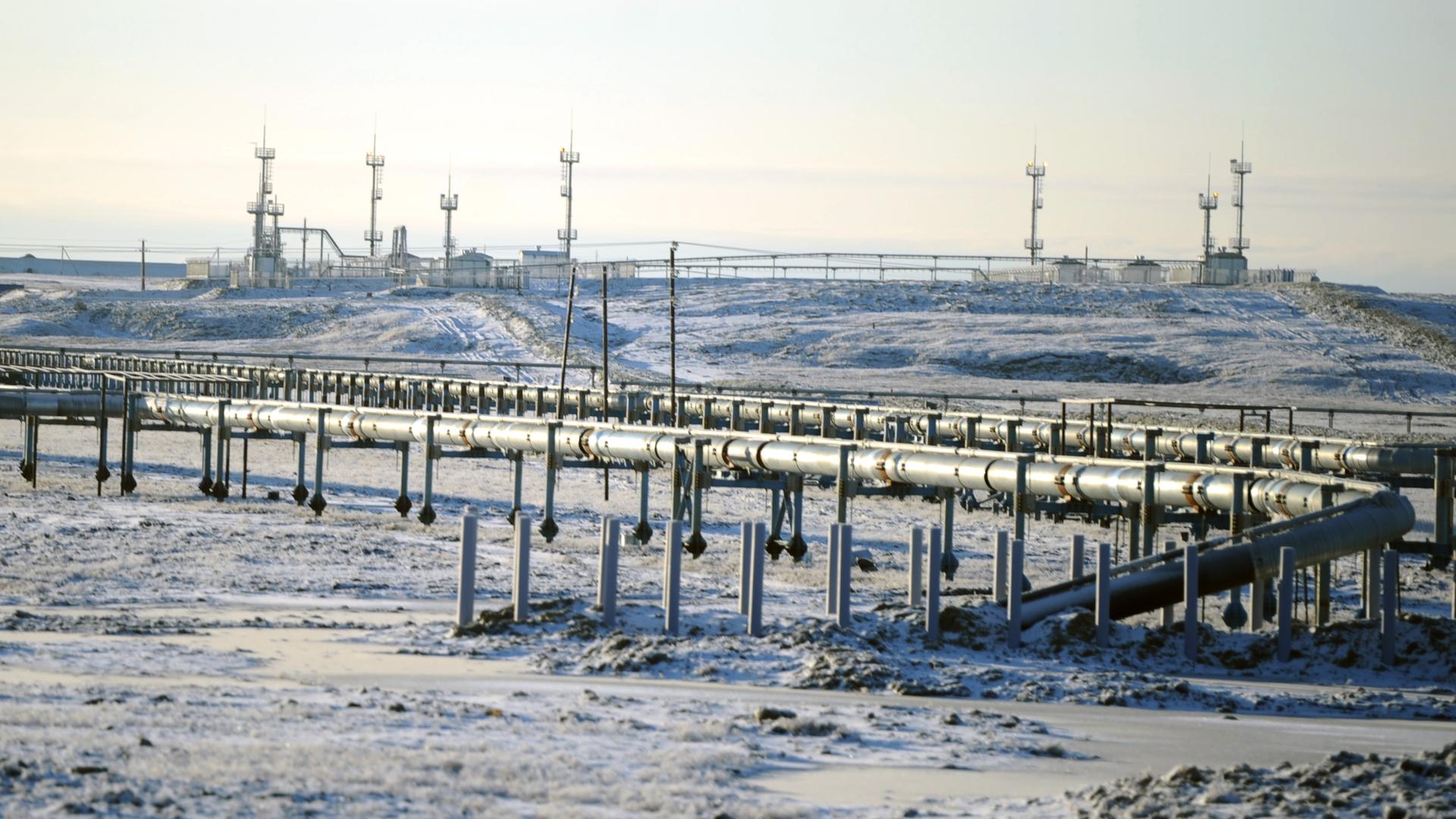 Eine Pipeline in Russland. Im Hintergrund sieht man Bohrtürme.