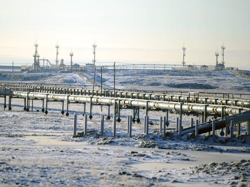 Eine Pipeline in Russland. Im Hintergrund sieht man Bohrtürme.