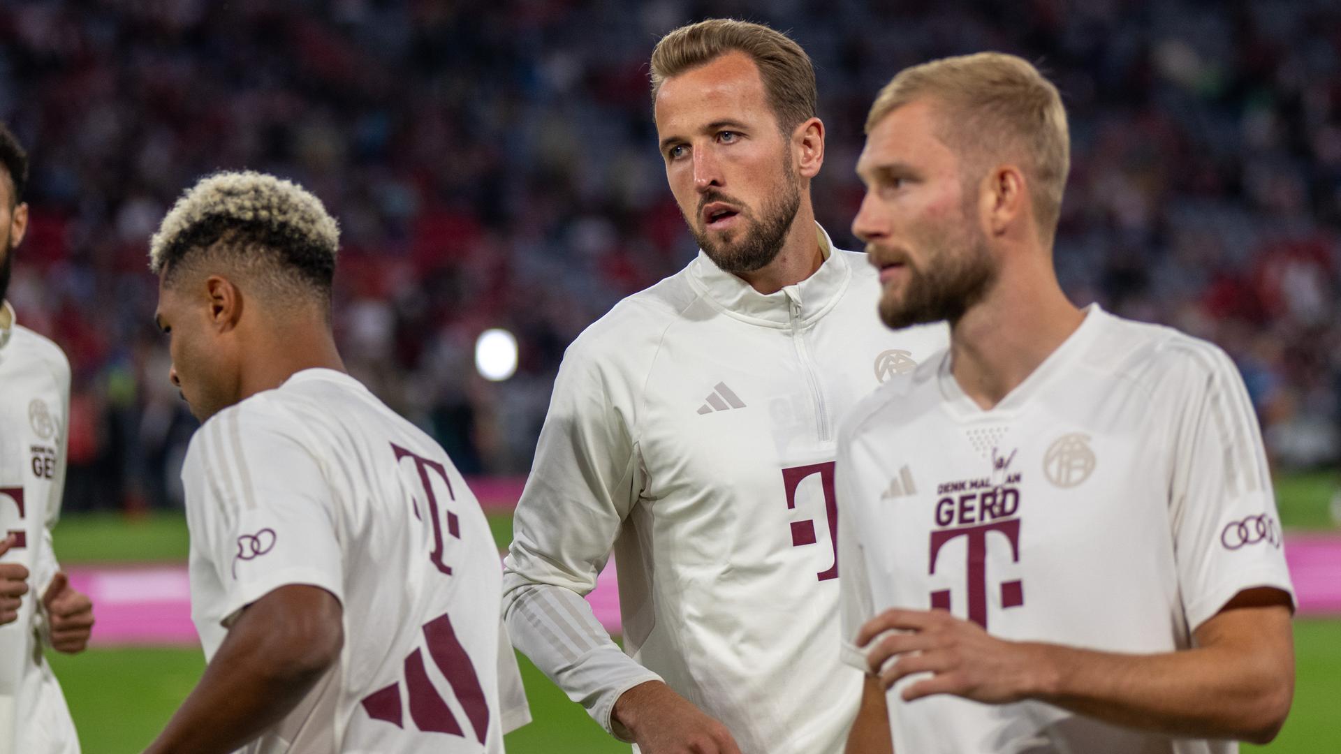 Harry Kane (Mitte) mit Mitspielern auf dem Spielfeld in der Allianz Arena in München, Aufnahme vom 15.09.2023