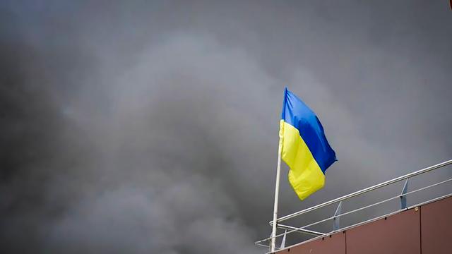 Ukraine, Dnipro: Auf diesem von der Regionalverwaltung Dnipropetrowsk veröffentlichten Foto weht die ukrainische Flagge, während nach einem russischen Raketenangriff Rauch aufsteigt. 