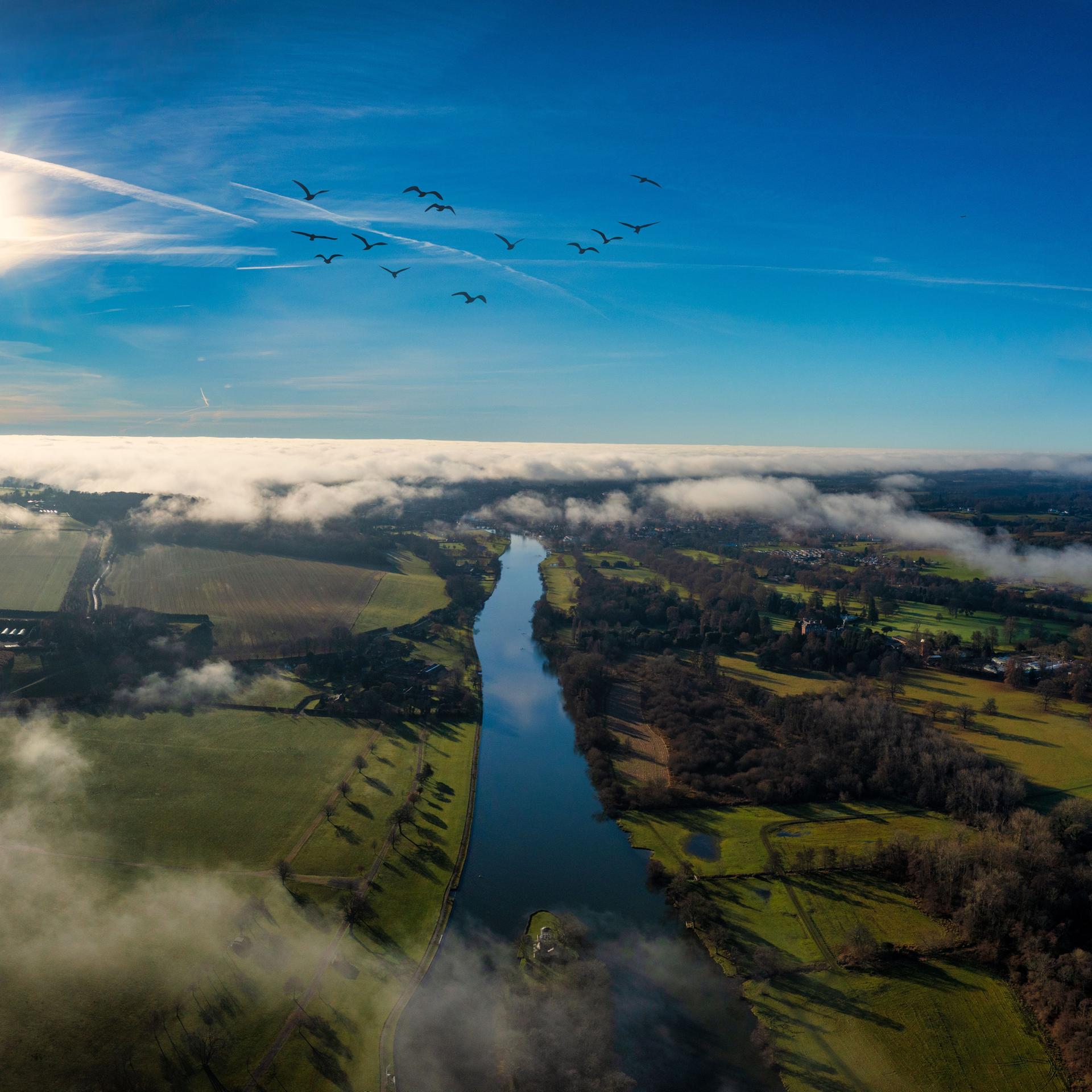 Ein Luftbild der Stadt Henley-on-Thames umgeben von grünen Feldern und Wasser.
