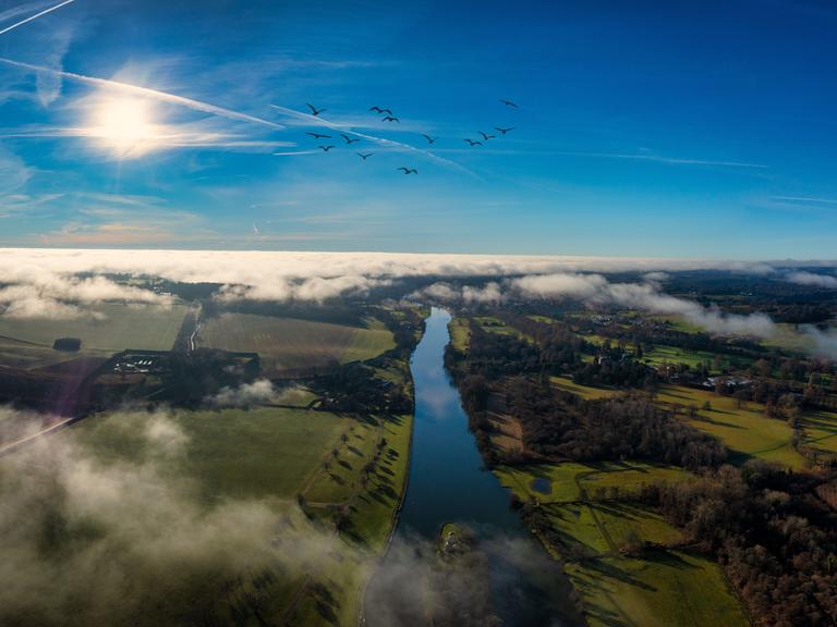 Ein Luftbild der Stadt Henley-on-Thames umgeben von grünen Feldern und Wasser.