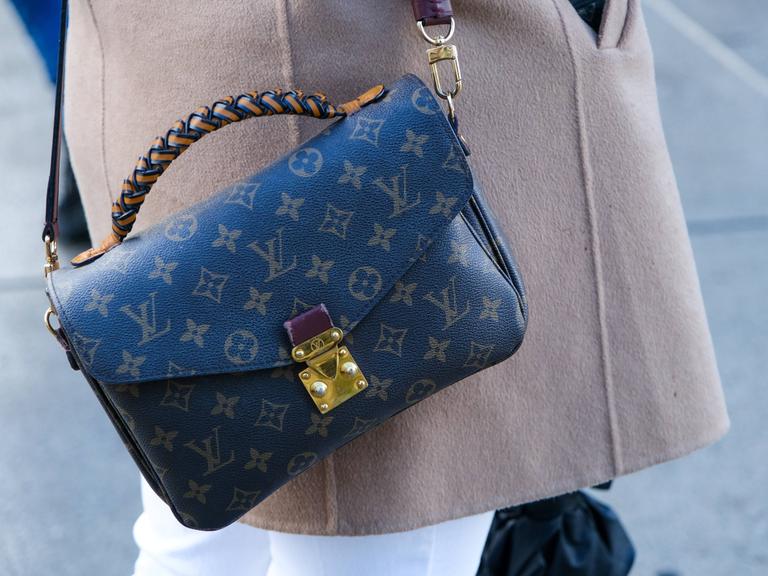 Eine Frau trägt eine Louis Vuitton Pochette Metis Schultertasche