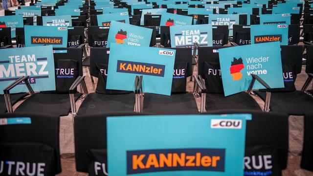 Plakate mit der Aufschrift "Kannzler", mit zwei N, liegen beim Bundesparteitag der CDU auf den Stühlen der Delegierten. 